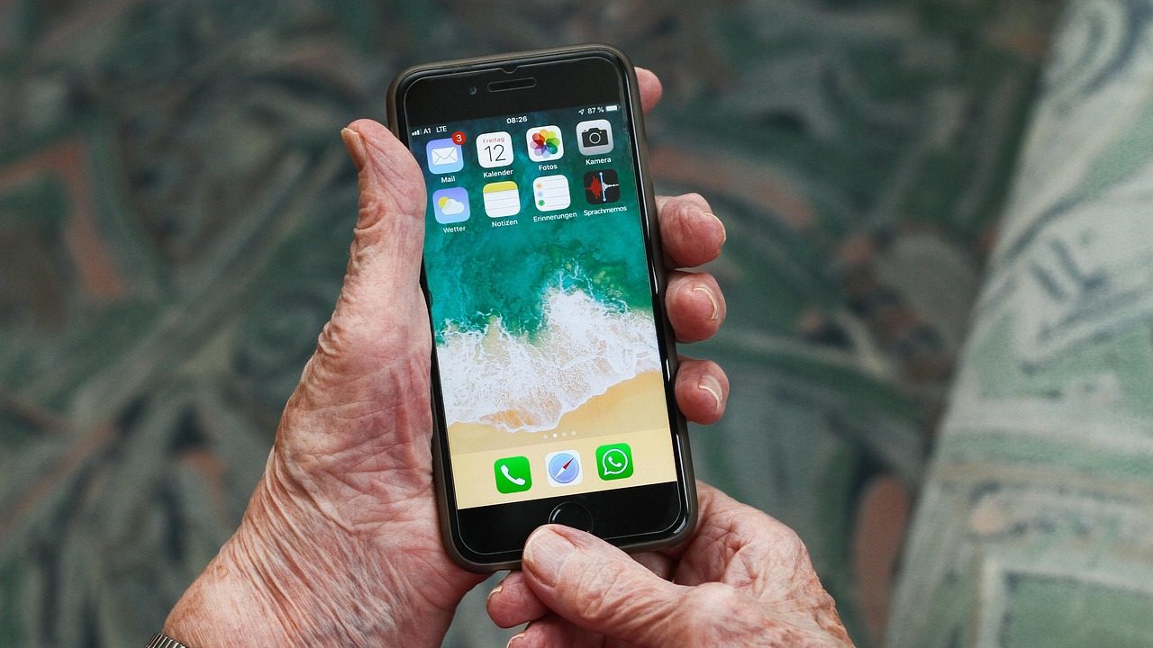 Smartphone dans les mains d'une personne âgée