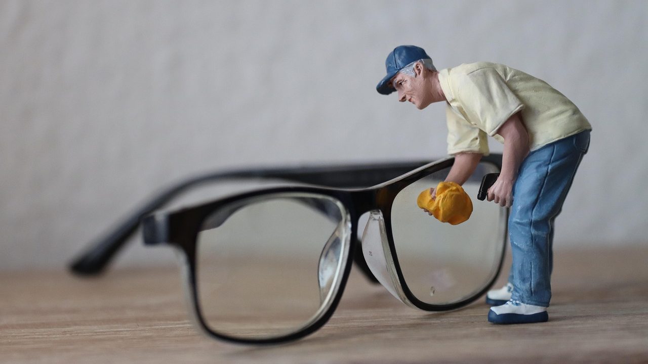 Une figurine d'homme qui nettoie des lunettes grandeur nature