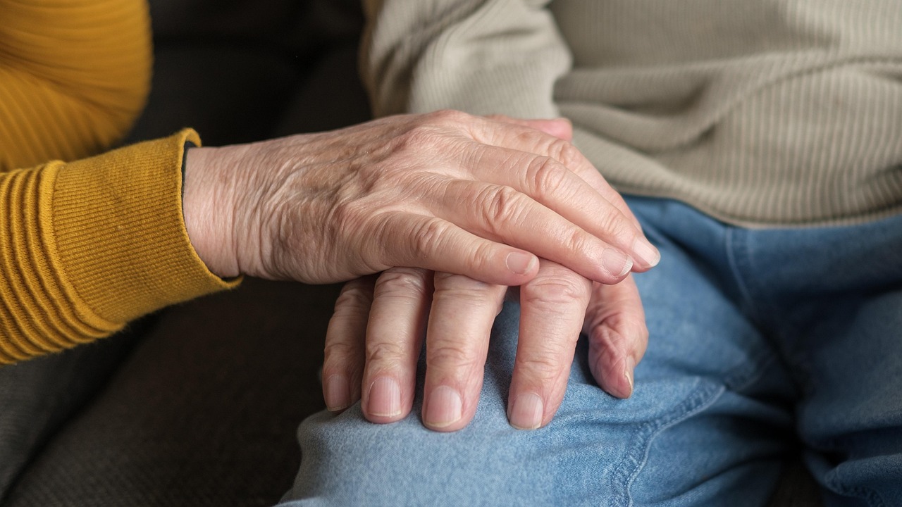 Une main posée sur celle d'une personne âgée