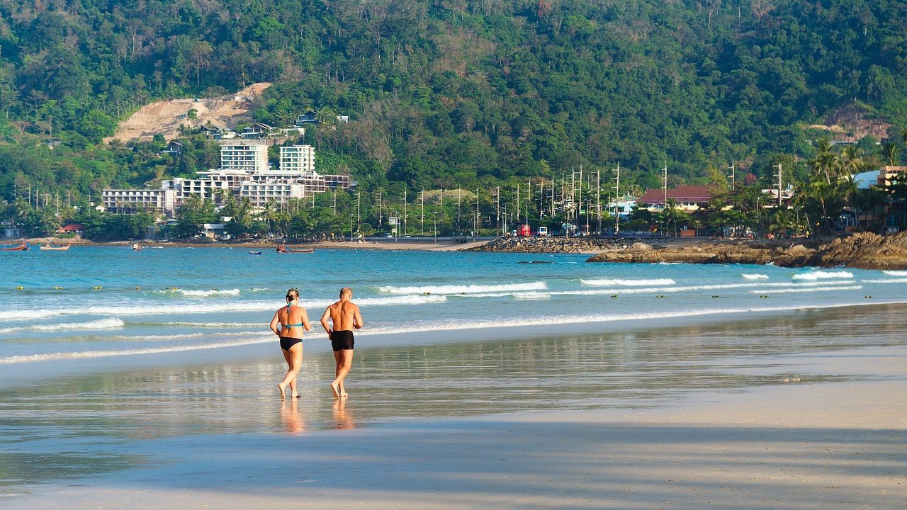 Un couple de seniors qui courent sur la plage